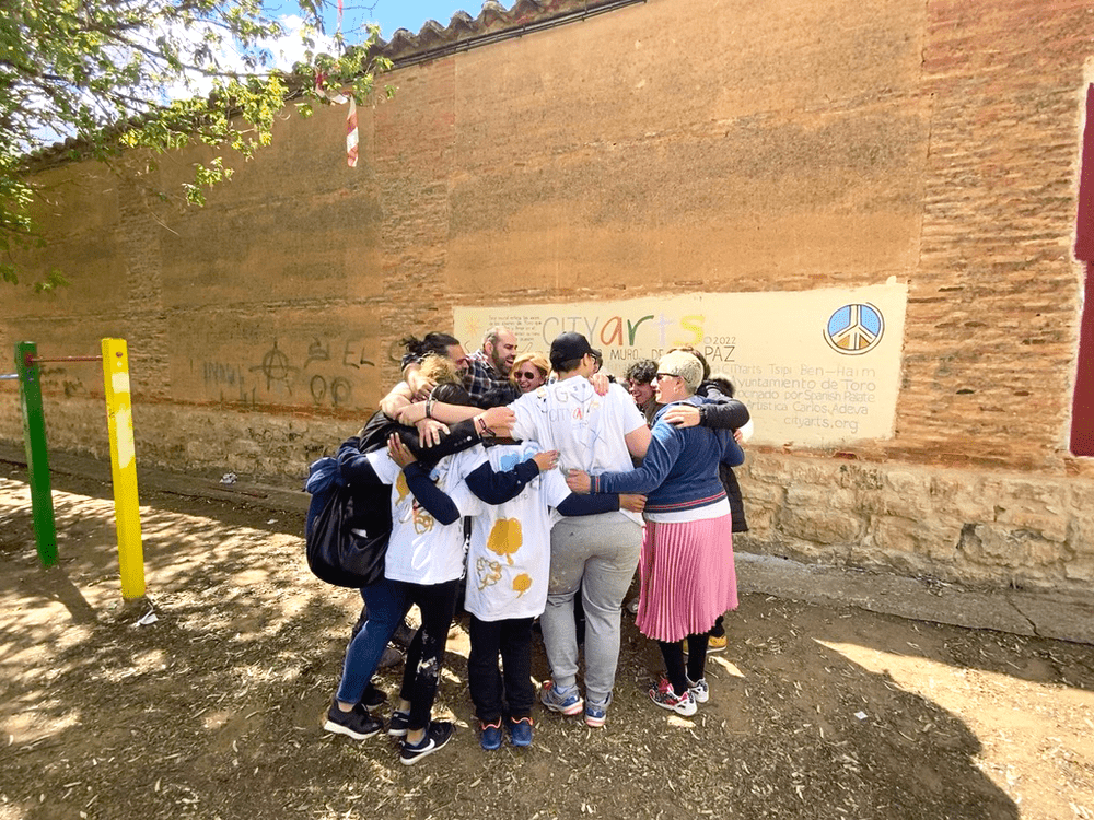 Young people in a huddle in front of the wall they finished